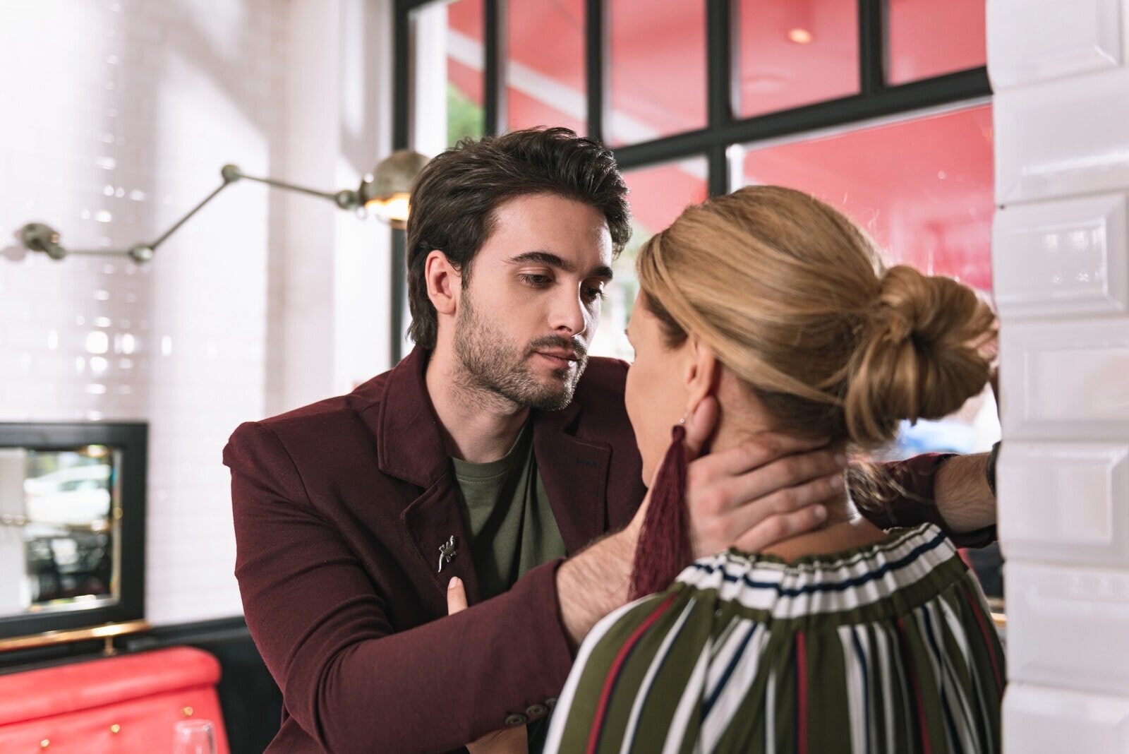 controlling man with hand on woman's neck, but not in a violent way