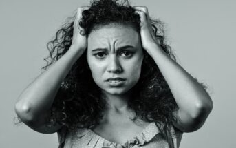woman struggling with thought loops holding her head in despair