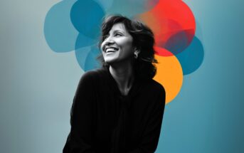 A smiling woman sits against a blue background with overlapping, translucent circles in blue, red, and yellow behind her head, creating an artistic and vibrant effect.